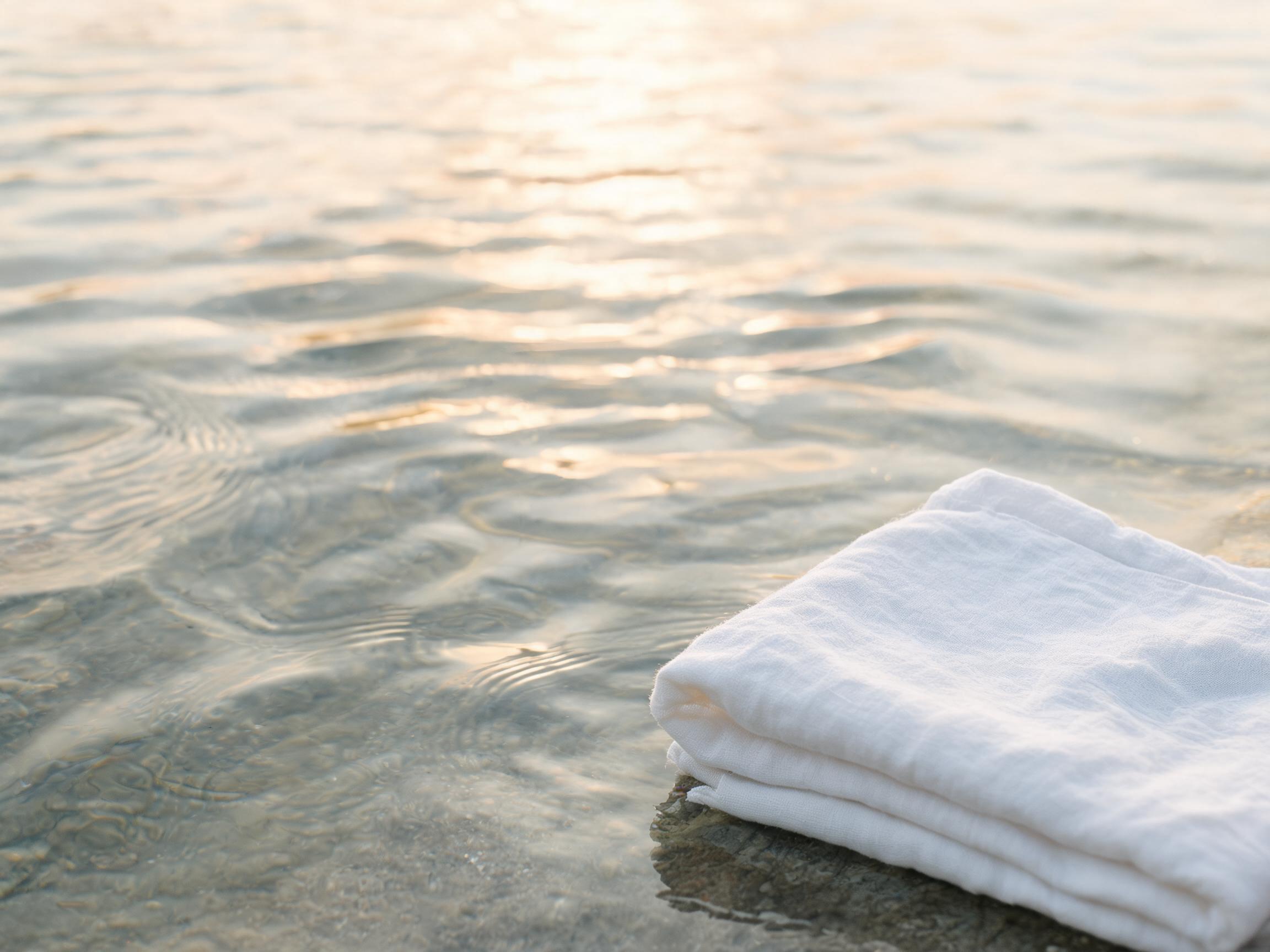 Clear water rippling beside a folded white cloth
