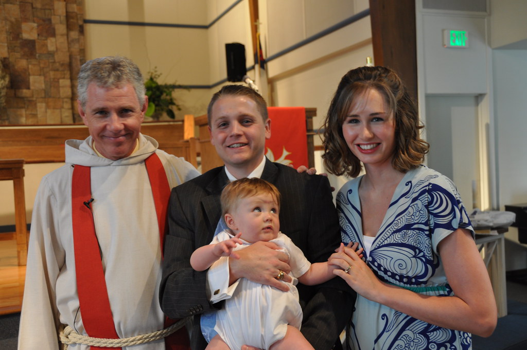 A minister holding a baby during a baptism blessing ceremony